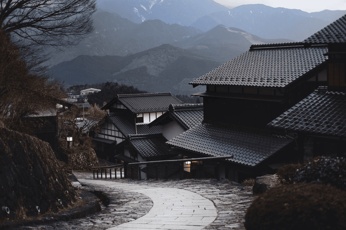 瓦屋頂山村與蜿蜒石路的環境畫面。