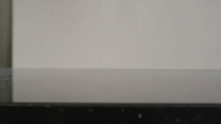 Metal press descending onto a glass vessel